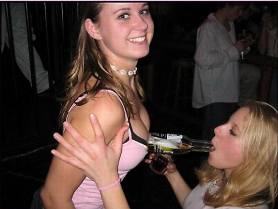 девушка пьет пиво из груди подруги